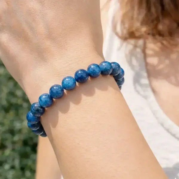 Bracelet en Apatite bleue naturelle porté par un mannequin, mettant en valeur les reflets bleu néon et la qualité des perles artisanales.