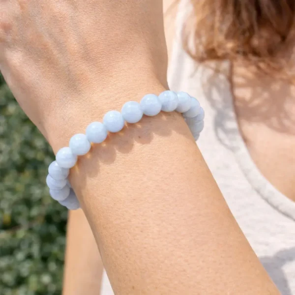 Bracelet en Calcédoine bleue véritable porté au poignet, révélant la douceur de sa couleur bleu pastel et la finesse du travail artisanal.