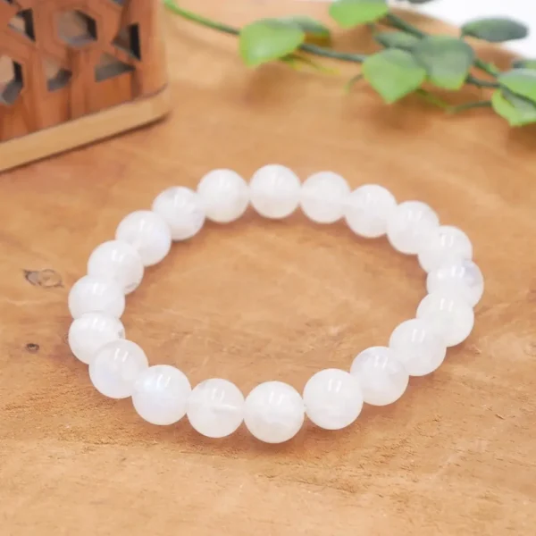 Bracelet en Péristérite naturelle (Labradorite blanche) aux reflets bleus intenses, perles blanches translucides sur fil élastique résistant.