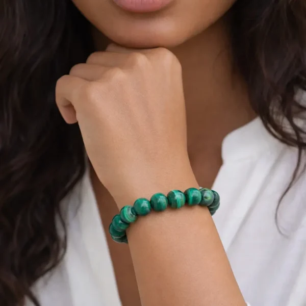 Bracelet en Malachite naturelle du Congo sur poignet femme monté sur fil élastique résistant.