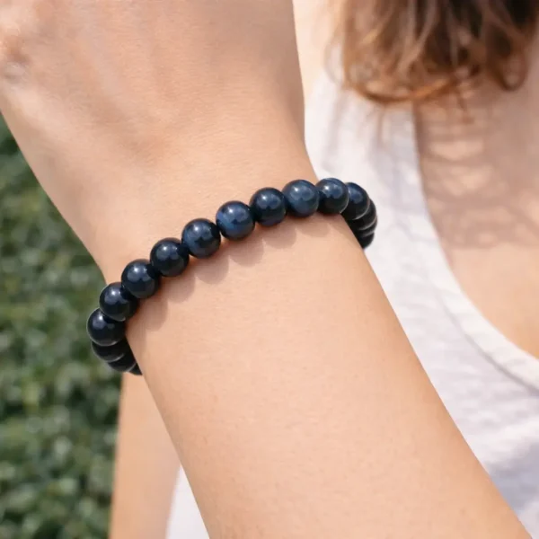 Bracelet en œil de faucon naturel avec reflets bleu pétrole porté au poignet