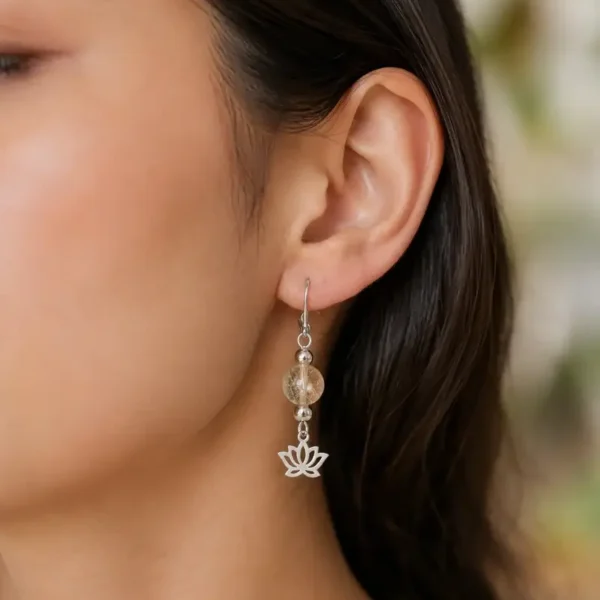 Modèle femme portant une paire de boucles d’oreilles en citrine naturelle jaune doré, montée sur des crochets en acier inoxydable argenté.
