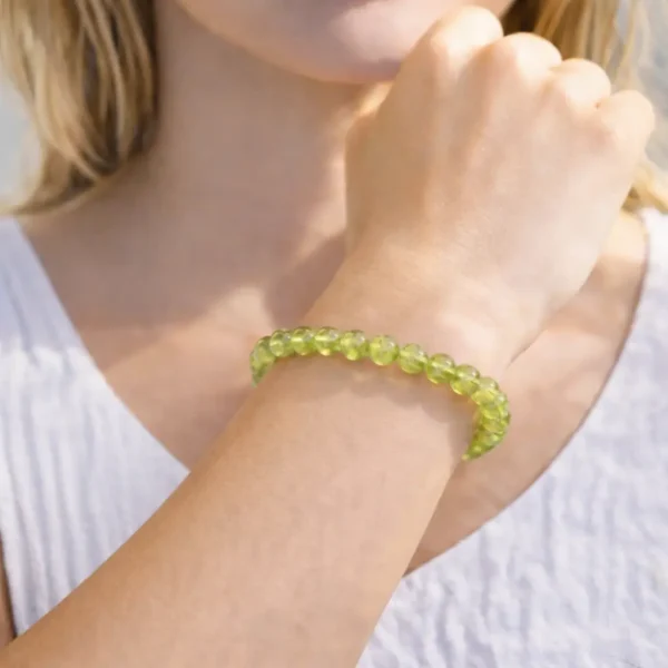 Bracelet en Péridot naturel porté au poignet, perles translucides vert olive éclatant de qualité gemme, création artisanale sur fil résistant.