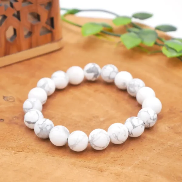 Bracelet en Howlite naturelle de qualité supérieure, perles blanches marbrées de gris montées sur fil élastique multibrin résistant.