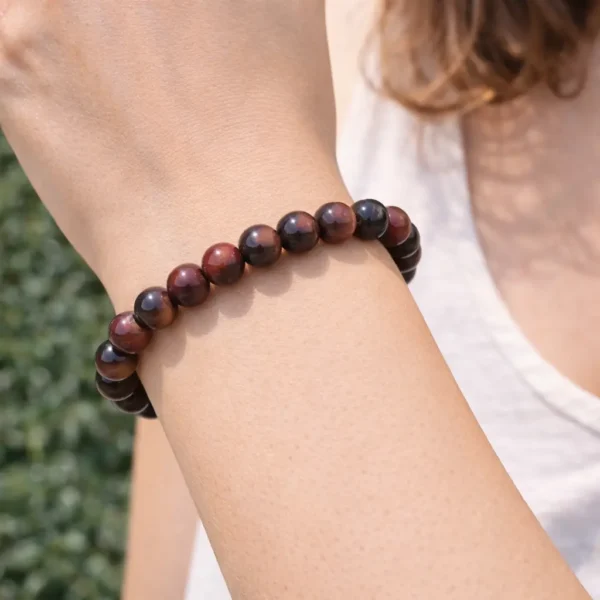 Bracelet en œil de taureau naturel aux reflets rouge brique et cuivré porté au poignet