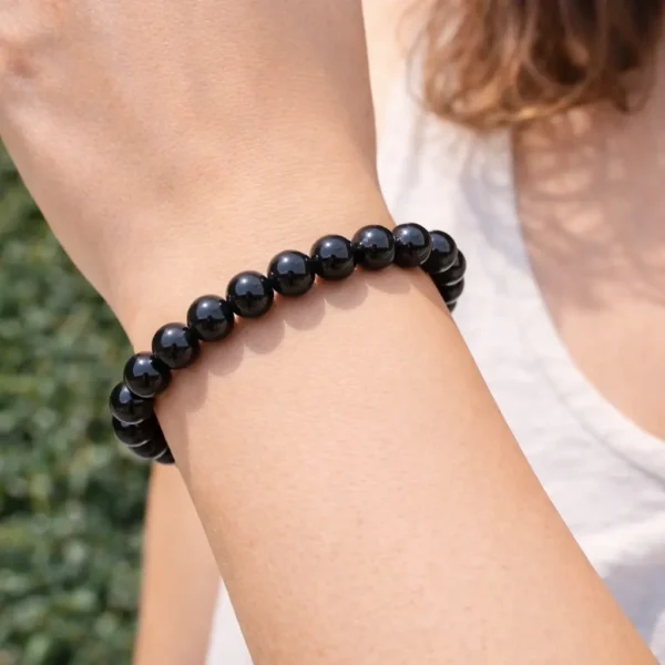 Bracelet en perles rondes de spinelle noir naturel poli porté au poignet