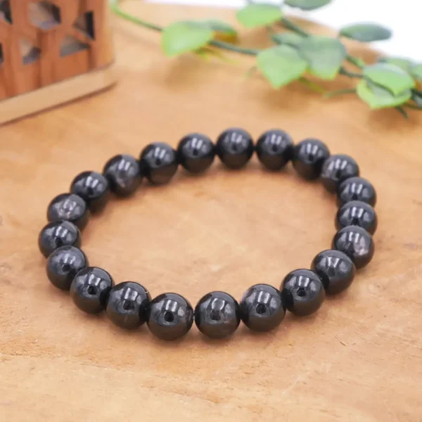 Bracelet en Hypersthène naturelle de qualité supérieure, perles noires aux reflets métalliques bronze montées sur fil élastique multibrin résistant.