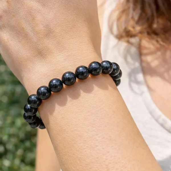 Bracelet en hypersthène naturelle fait main sur fil élastique porté au poignet