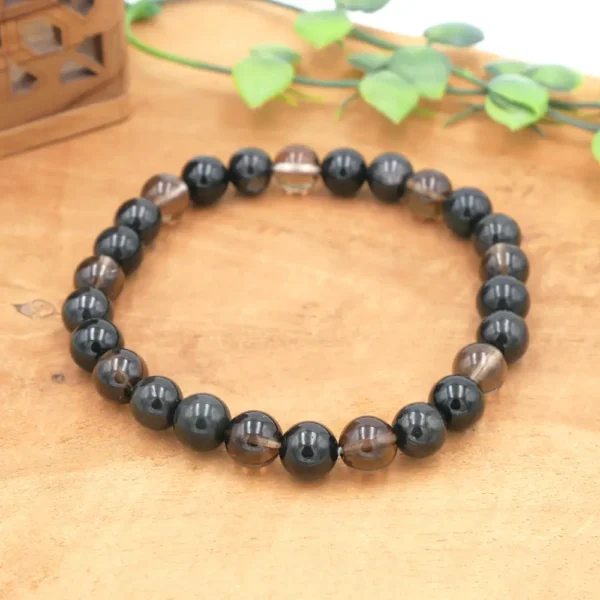 Photo d'un Bracelet composé des pierres naturelles hyperstène, obsidienne noire, quartz fumé et tourmaline noire sur fil élastique multibrin.